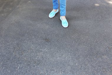 Kadın ayakları üzerinde gri arka plan asfalt
