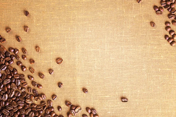 Frame of coffee beans on color sackcloth background — Stock Photo, Image