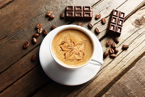 Cup 的咖啡拿铁艺术与谷物和巧克力对木制背景 — 图库照片