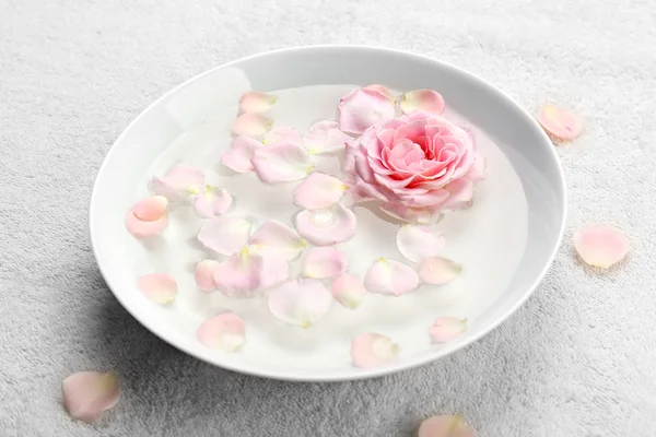 Schüssel mit Aroma-Thermalwasser mit Rosenblättern auf Handtuch, Nahaufnahme — Stockfoto