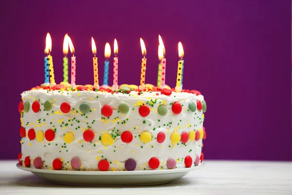 Torta di compleanno con candele su sfondo viola — Foto Stock