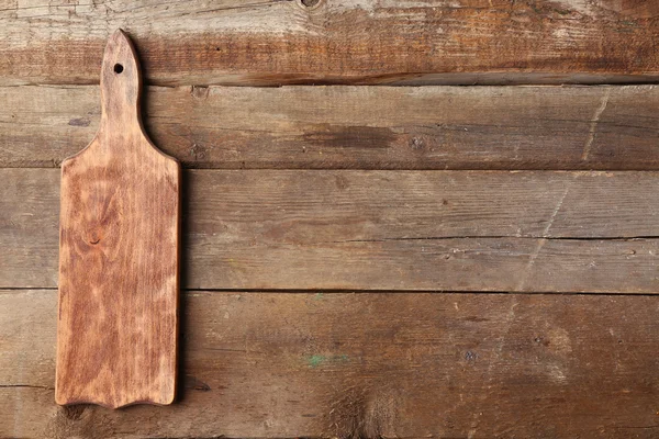 Cutting board on wooden background — Stock Photo, Image