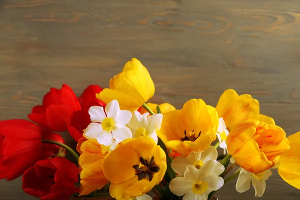 Beautiful bouquet of tulips and narcissus on wooden background — Stock Photo, Image