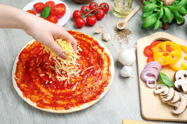 Frau macht Pizza auf Tisch aus nächster Nähe — Stockfoto