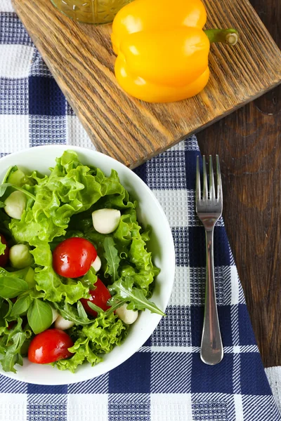 Färska grönsaker sallad i skål på bordet på nära håll — Stockfoto