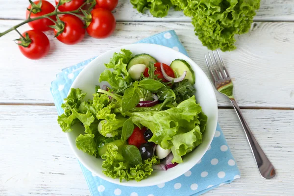 Färska grönsaker sallad i skål på bordet på nära håll — Stockfoto