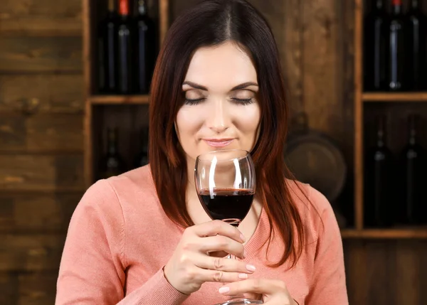 Νεαρή γυναίκα γευσιγνωσίας κρασιού στο κελάρι — Φωτογραφία Αρχείου