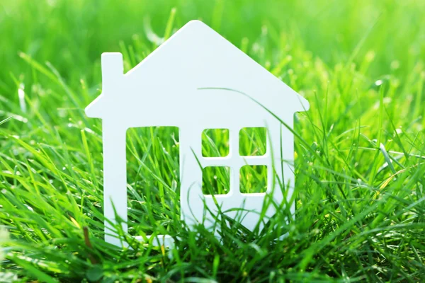 Small model of house over green grass background — Stock Photo, Image