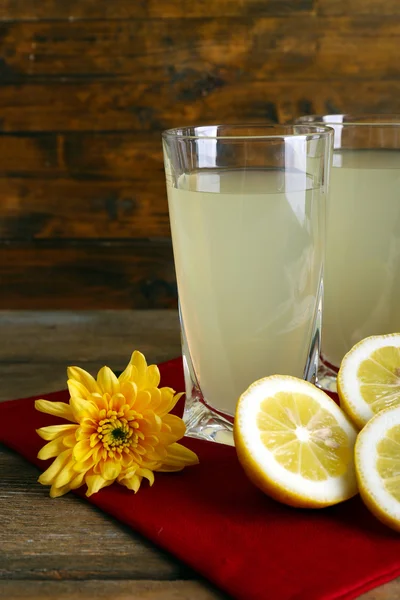Limon suyu ve ahşap zemin üzerine dilimlenmiş limon ile natürmort — Stok fotoğraf