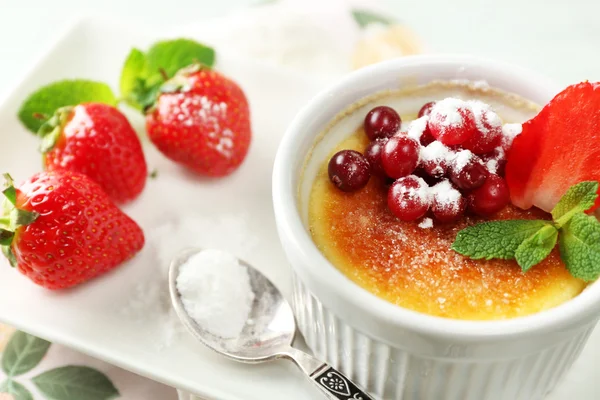 Creme Brulee Dessert mit frischen Erdbeeren und Minzblättern, auf farbigem Holzhintergrund — Stockfoto