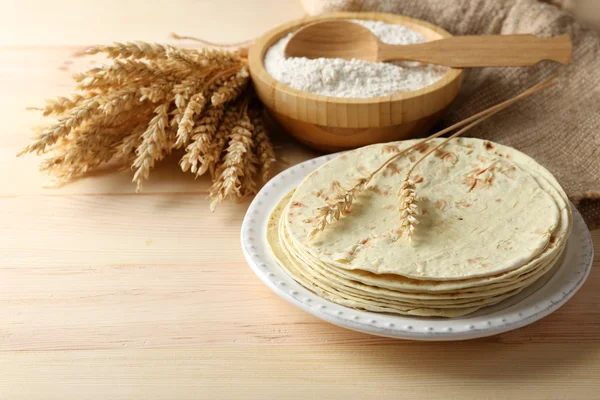 Pilha de tortilla de farinha de trigo integral caseira na placa, no fundo da mesa de madeira — Fotografia de Stock