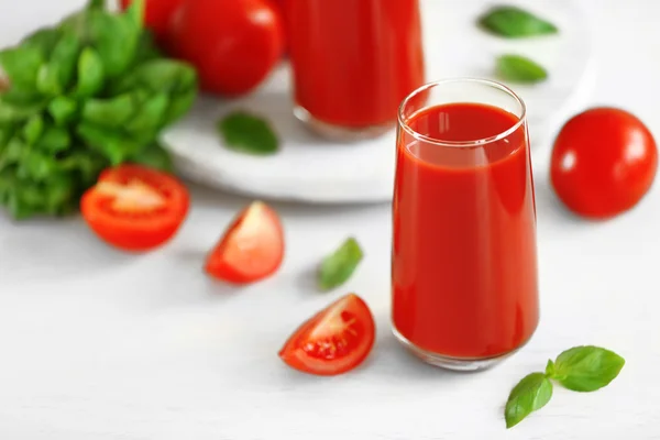 Jugo de tomate y tomates frescos en primer plano de mesa de madera —  Fotos de Stock