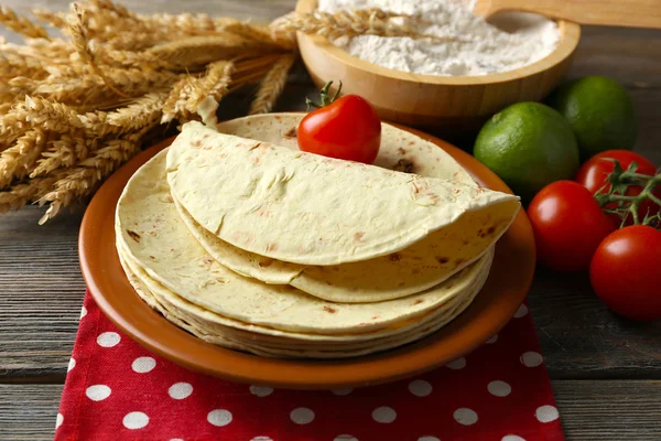 Lot de tortillas et légumes de farine de blé entier maison sur assiette, sur fond de table en bois — Photo