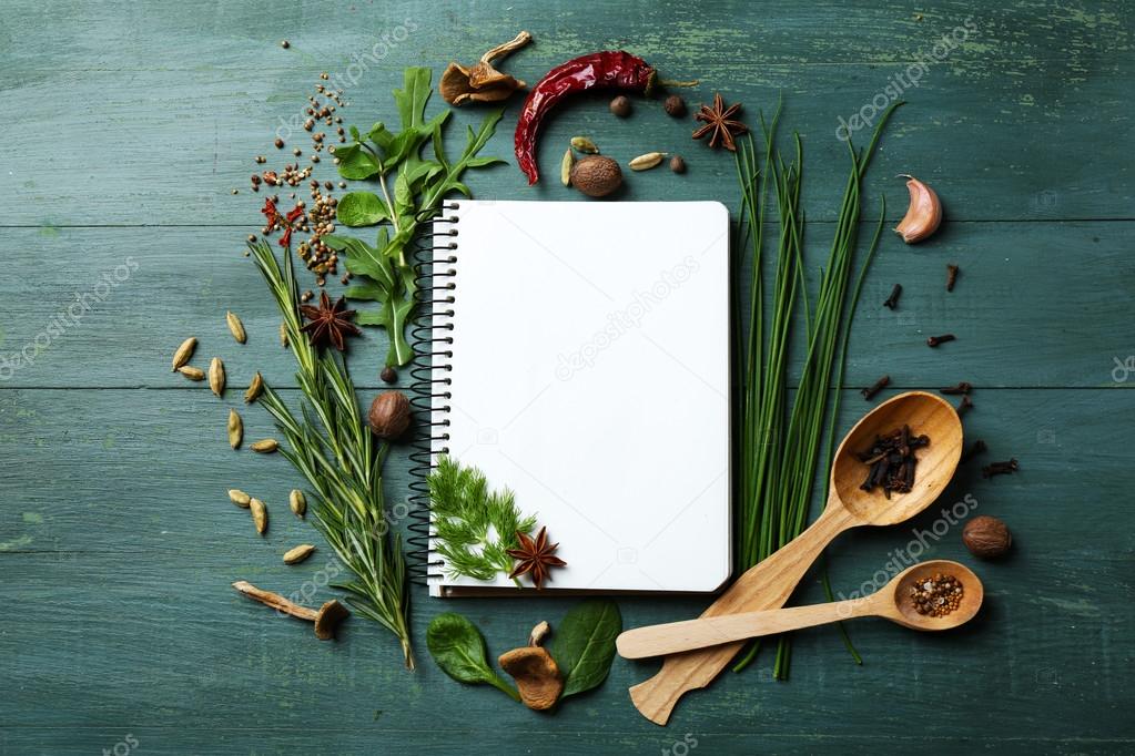 recipe book with fresh herbs and spices