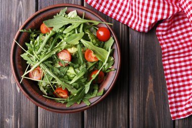 Roka ve ahşap masa üzerinde domates salatası