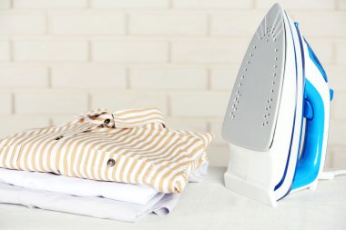 giyim ve tuğla duvar arka plan üzerinde elektrik demir yığını