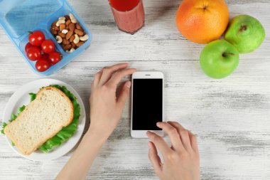 Gıda ve eller içinde hareket eden telefon