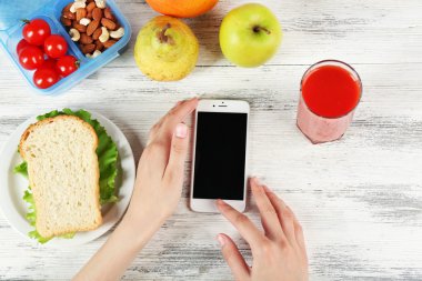 Gıda ve eller içinde hareket eden telefon
