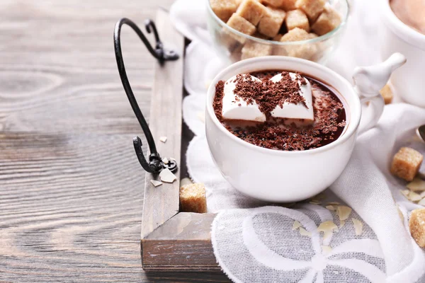 Cioccolata calda con marshmallow in tazza, su vassoio, su sfondo di legno a colori — Foto Stock