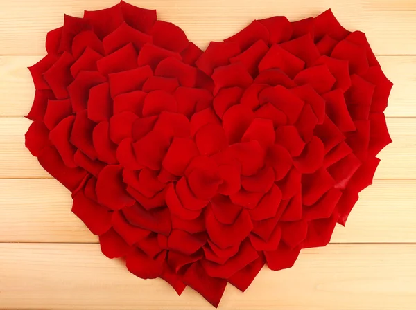 Serce z płatków róż na drewniane tła — Zdjęcie stockowe