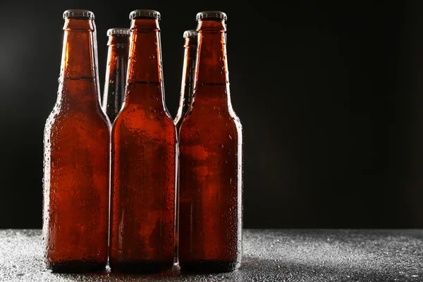 Bottiglie di vetro di birra su sfondo scuro — Foto Stock