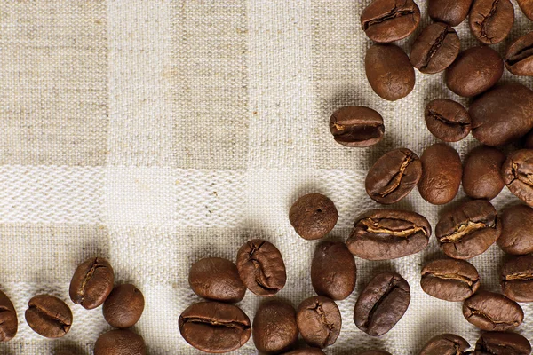 Frame of coffee beans on color sackcloth background — Stock Photo, Image