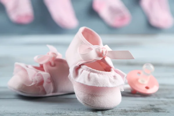 Niedliche Kleinkindschuhe auf hölzernem Hintergrund — Stockfoto