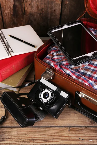 Packing suitcase for trip on wooden background — Stock Photo, Image