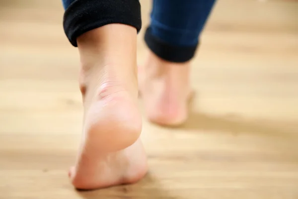 Beautiful female legs on wooden floor background — Stock Photo, Image