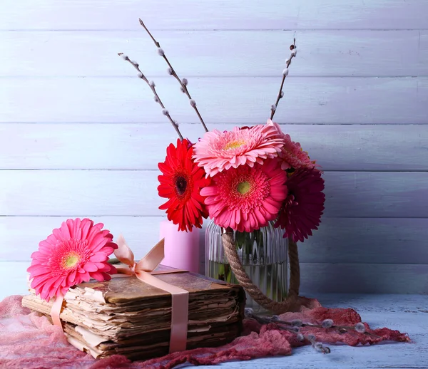 Gerberas in vase with old book — Stock Photo, Image