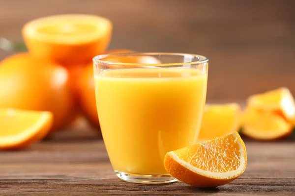 Sumo de laranja na mesa no fundo de madeira — Fotografia de Stock