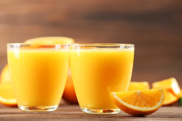 Jugo de naranja sobre mesa sobre fondo de madera —  Fotos de Stock