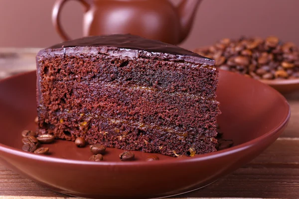 Lezzetli çikolatalı pasta plaka tablo üzerinde kahve çekirdekleri ile yakın çekim — Stok fotoğraf