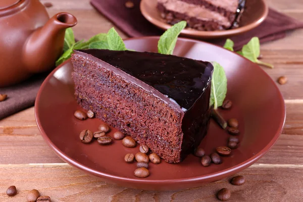 Delicious chocolate cake with mint on plate on table close up — Stock Photo, Image