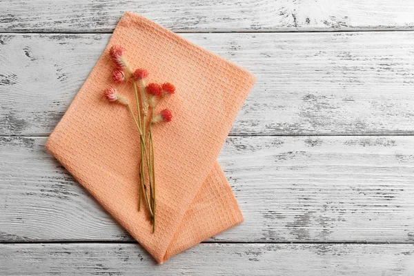 Hermosas flores secas en servilleta sobre fondo de madera —  Fotos de Stock