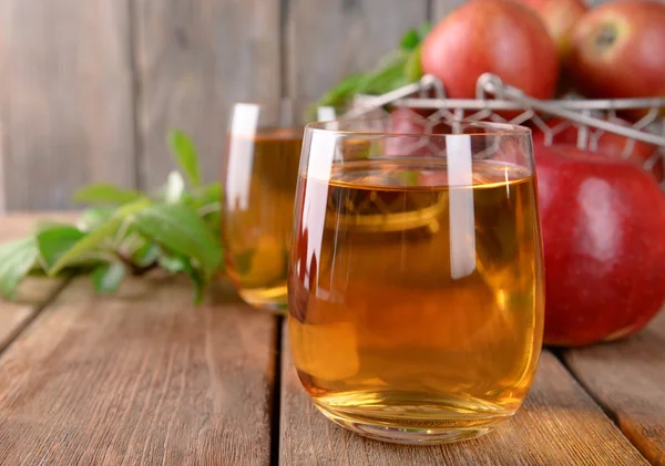 Verres de jus de pomme sur table en bois, gros plan — Photo