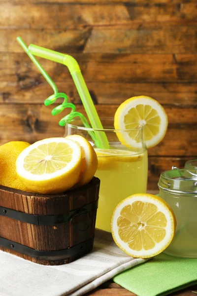 Bodegón con jugo de limón y limones en rodajas sobre fondo de madera —  Fotos de Stock