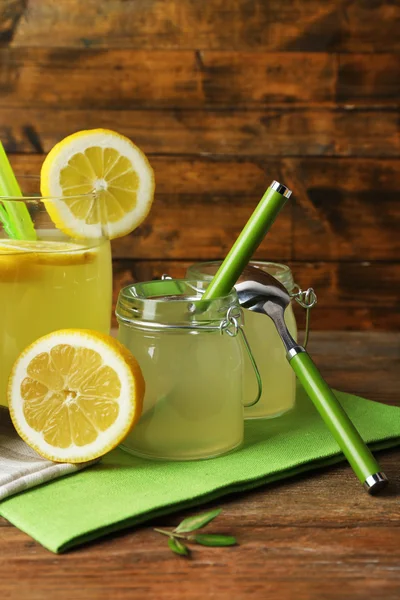 Still life with lemon juice and sliced lemons on wooden background — Stock Photo, Image