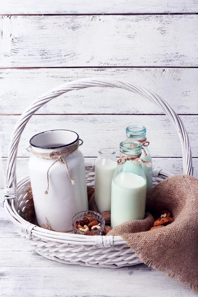 Leche en cristalería con nueces y galletas sobre fondo de madera —  Fotos de Stock