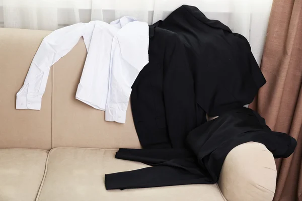 Ropa de escuela desordenada para niño en el sofá — Foto de Stock