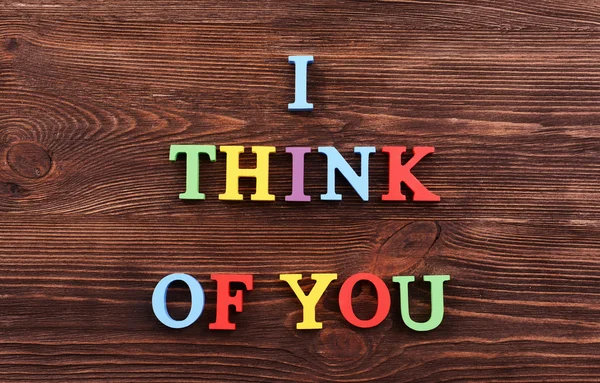 Надпись "Я думаю о тебе" сделана из красочных букв на деревянном фоне. — стоковое фото