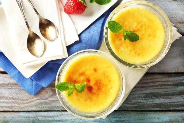 Creme brulee postre en servilleta, sobre fondo de madera de color — Foto de Stock