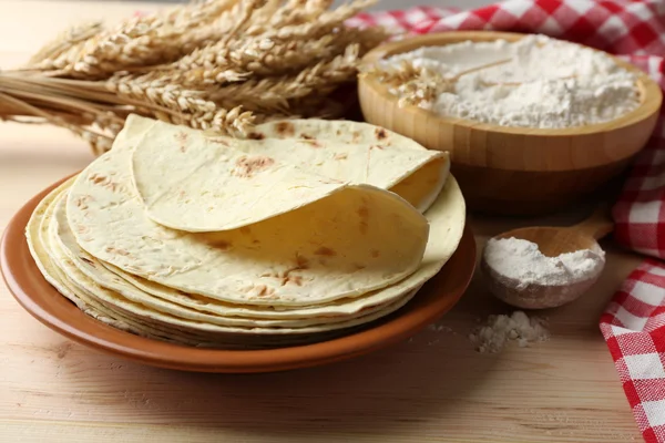 Stapel hausgemachter Tortilla auf Teller, auf Holztischhintergrund — Stockfoto