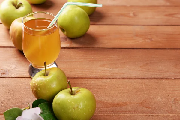 Glas appelsap en appels op houten tafel — Stockfoto