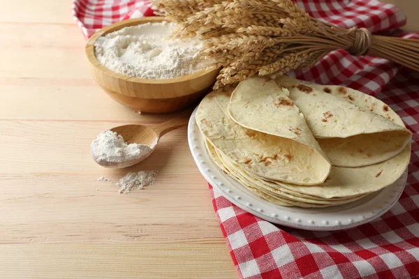 Bunt med hemmagjord tortilla på plattan, på träbord bakgrund — Stockfoto