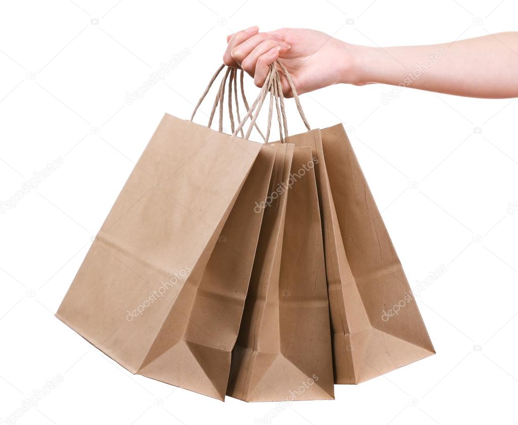 Female hand holding paper shopping bag isolated on white