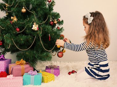 Noel ağacı süsleyen küçük kız