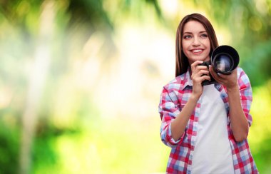 Genç kadın fotoğrafçı doğa arka plan üzerinde fotoğraf çekmek