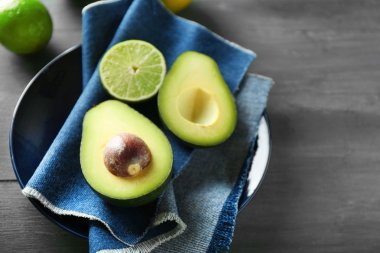 avokado ve limon kireç ahşap arka plan üzerine dilimlenmiş