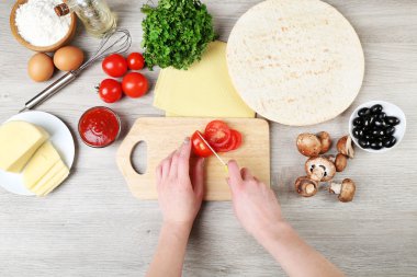 erkek pişirme pizza ahşap masa, closeup üzerinde eller